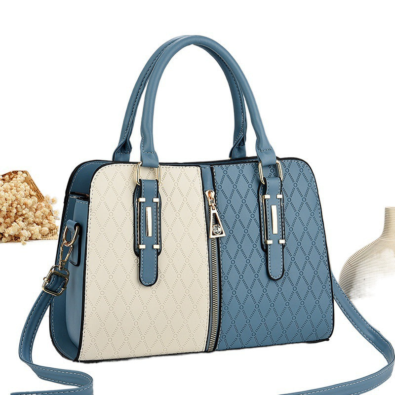 Bolso tote grande para mujer con diseño color-block en azul y crema, patrón geométrico y herrajes dorados.
