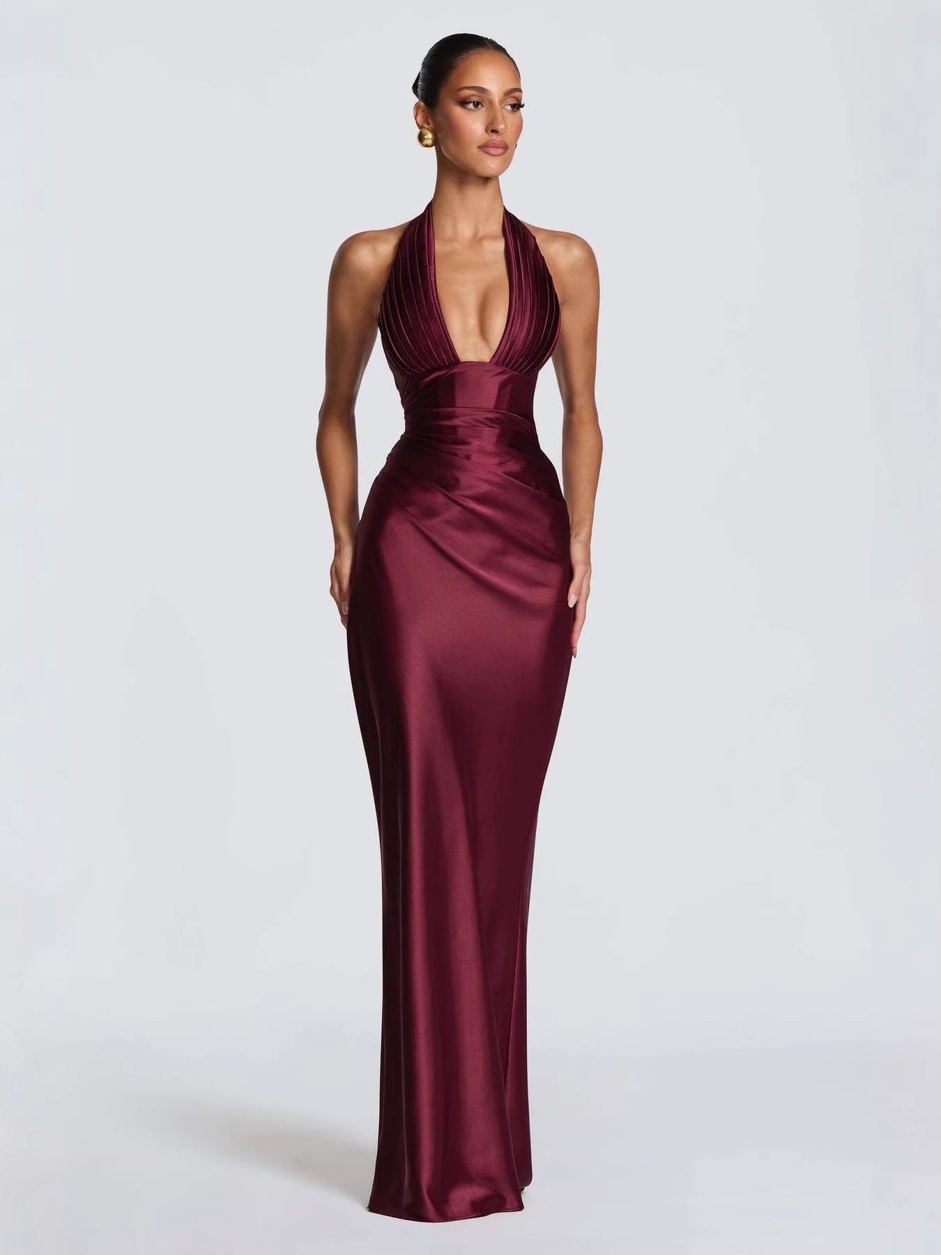Vestido largo de satén granate con escote en V profundo, cuello halter y silueta ajustada para fiesta.