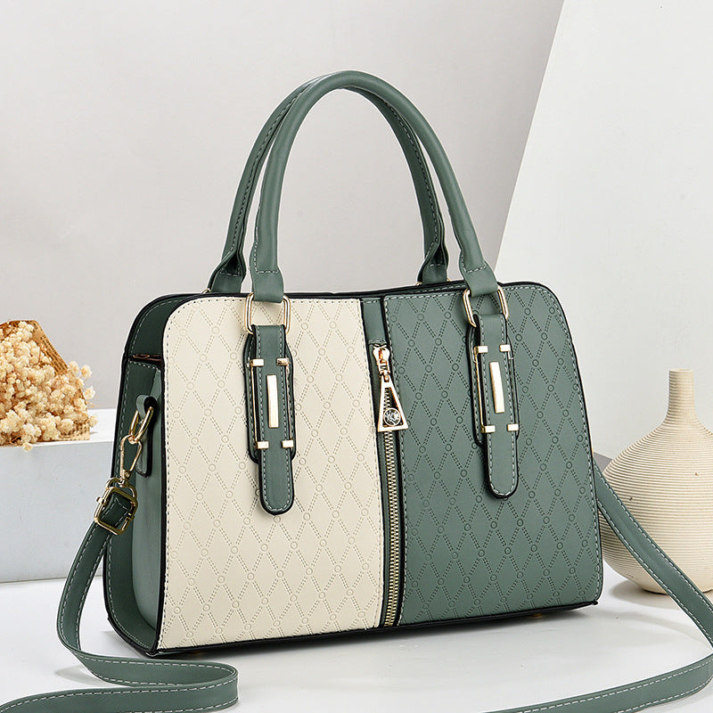 Bolso tote grande para mujer con diseño color-block verde y crema, textura grabada y herrajes dorados.