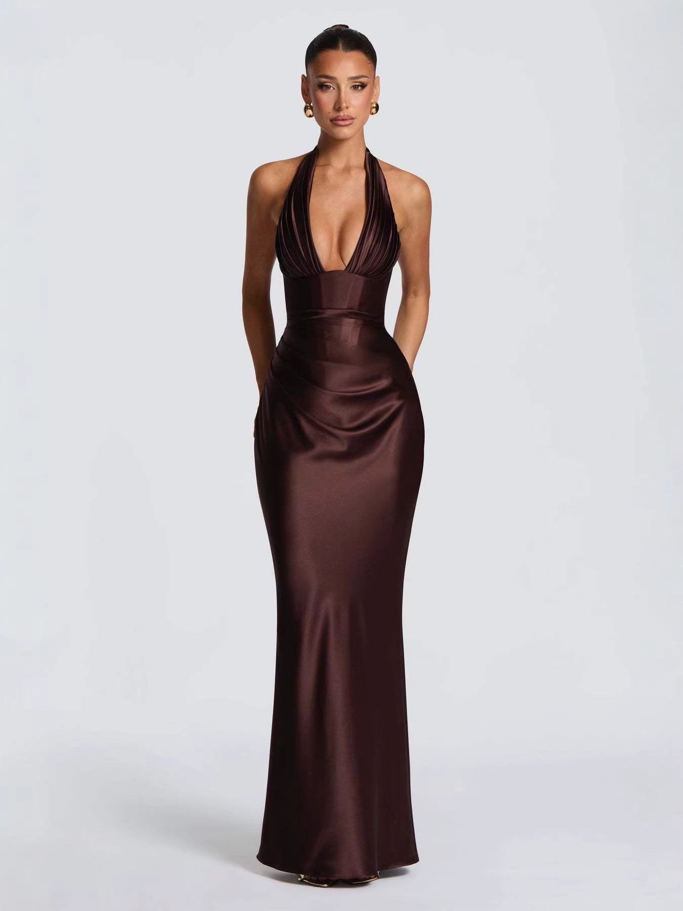 Vestido largo de satén marrón chocolate con escote en V profundo, cuello halter y silueta ajustada para fiesta.