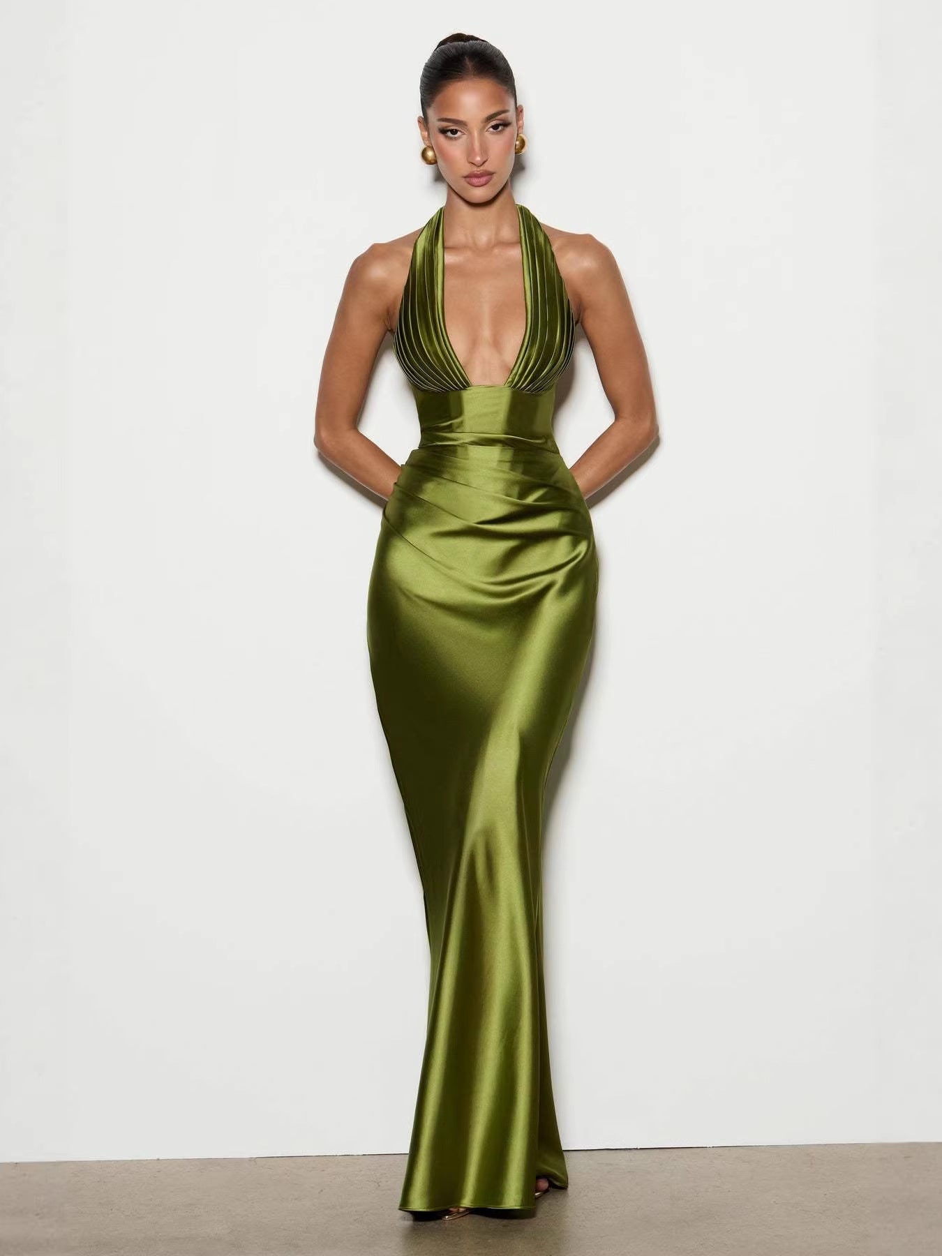 Vestido largo de satén verde oliva con escote en V profundo, diseño halter plisado y silueta entallada.