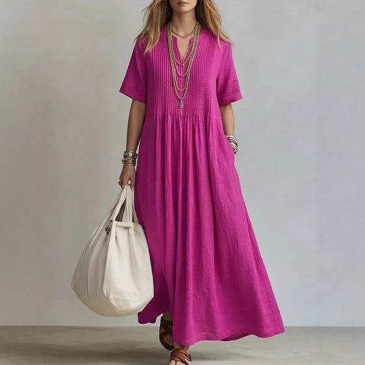 Vestido largo fucsia de algodón y lino con cuello en V, detalles plisados frontales y corte holgado casual.