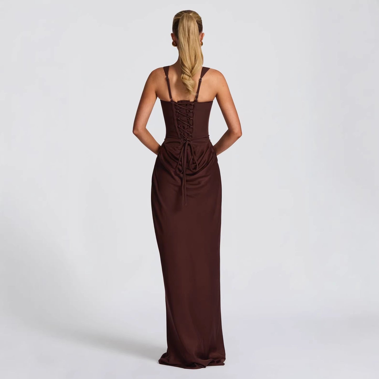 Vestido de noche largo color chocolate con espalda descubierta, cordones estilo corsé y ajuste bodycon elegante.