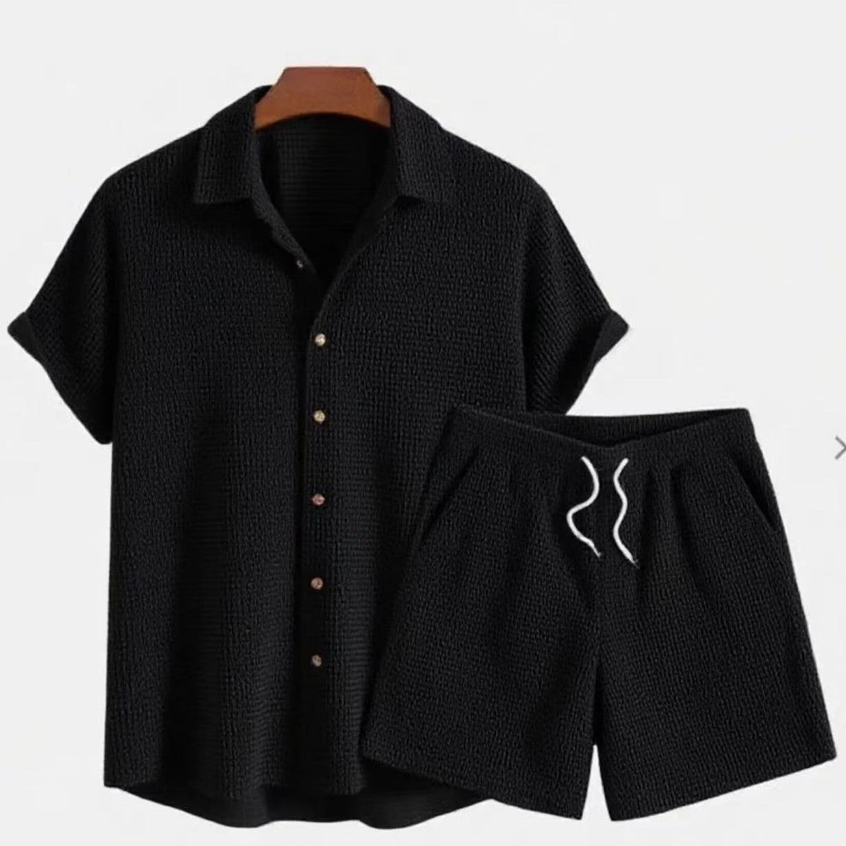 Conjunto casual para hombre negro con camisa de manga corta con botones y pantalón corto con cordón ajustable.