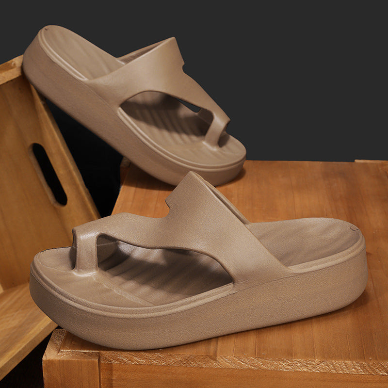 Chanclas de playa para mujer en color café con suela gruesa de EVA y diseño ergonómico de dedo sobre cajas de madera.