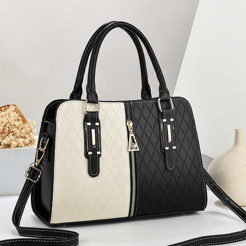 Bolso tote grande para mujer con diseño color-block en blanco y negro, textura acolchada y detalles dorados.