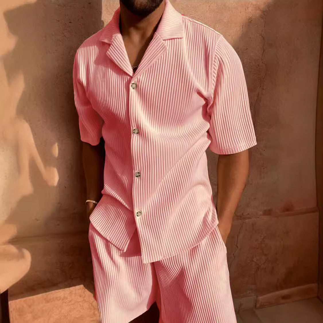 Conjunto de verano rosa para hombre con camisa de solapa y pantalón corto en tejido de pana con textura premium.