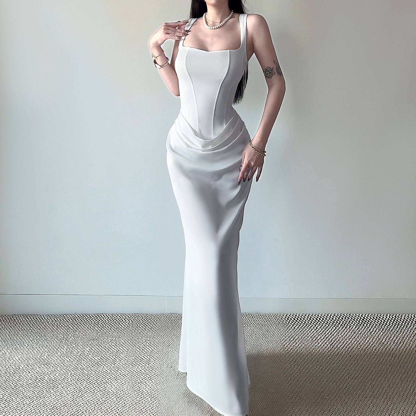 Vestido de noche blanco entallado estilo bodycon con falda larga de corte sirena y escote cuadrado.