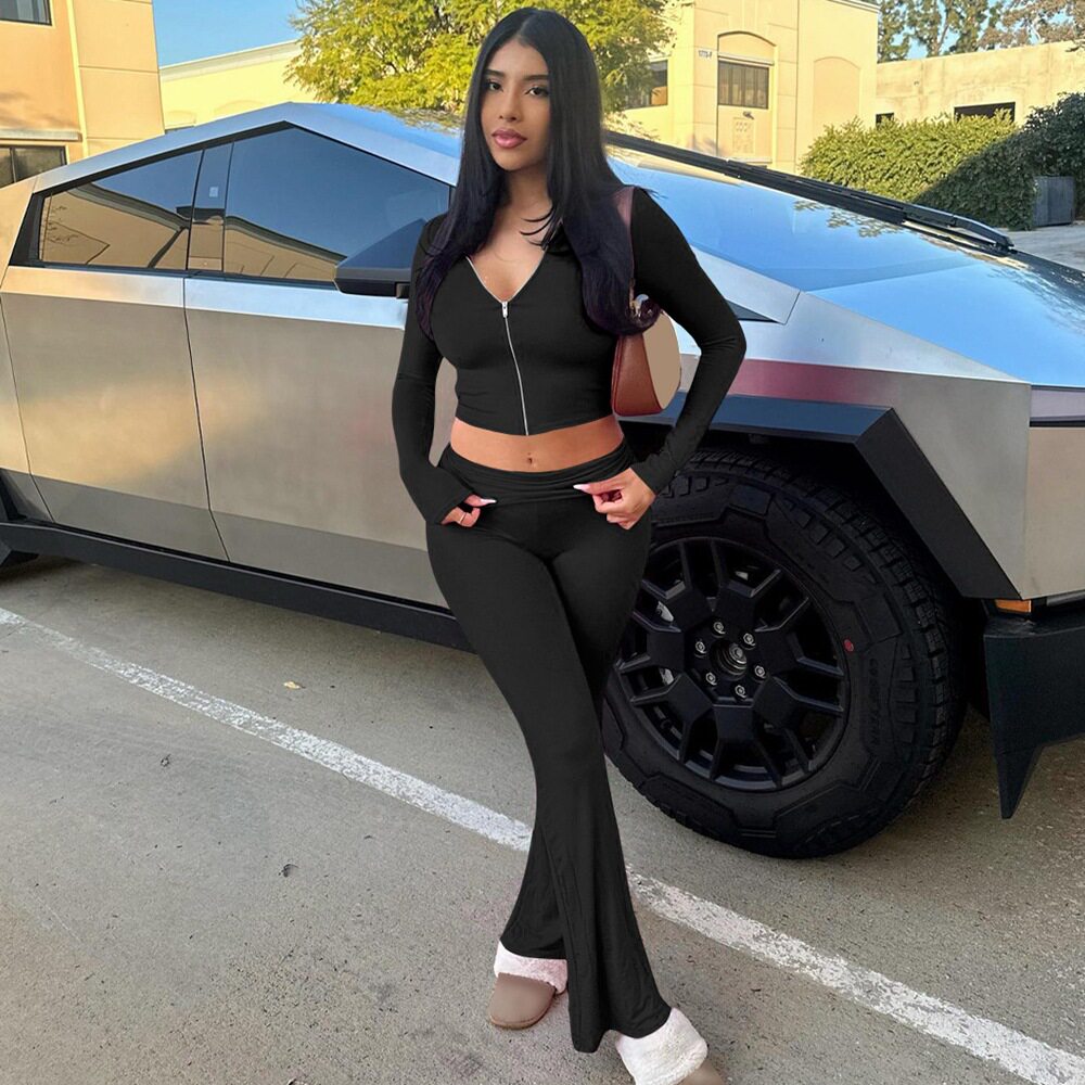 Chándal negro de mujer con top corto de cremallera y pantalones acampanados de talle alto.