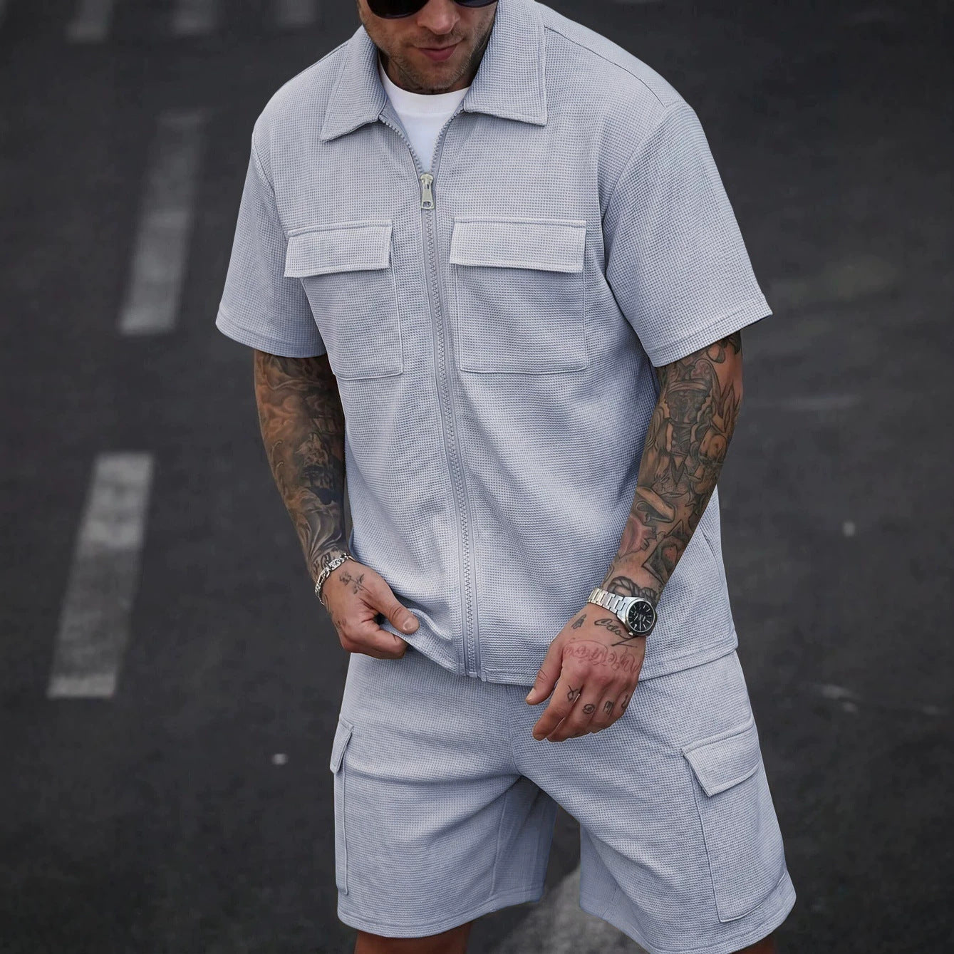 Hombre con conjunto de cárdigan con cremallera y shorts en tejido waffle gris, estilo casual de verano.