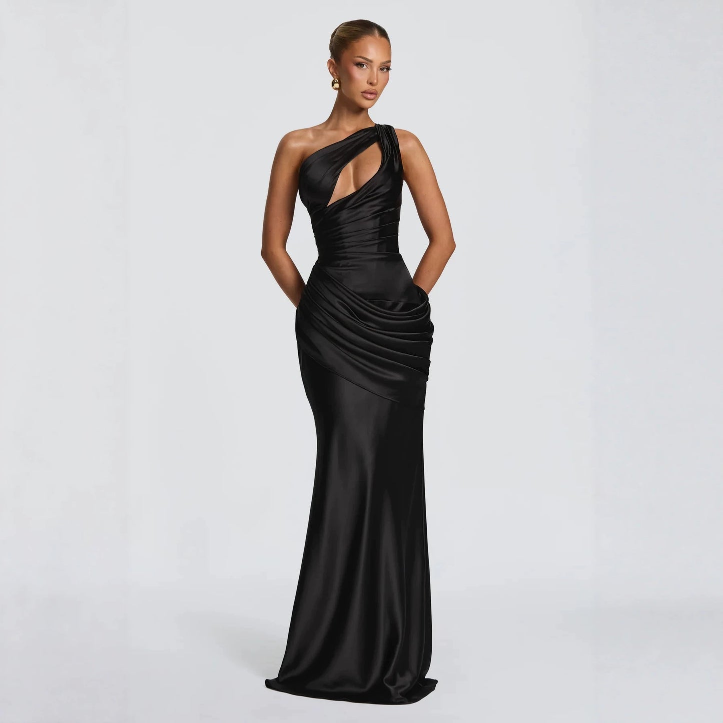 Vestido de noche negro corte sirena con diseño asimétrico de un hombro y elegante efecto drapeado en la cintura.