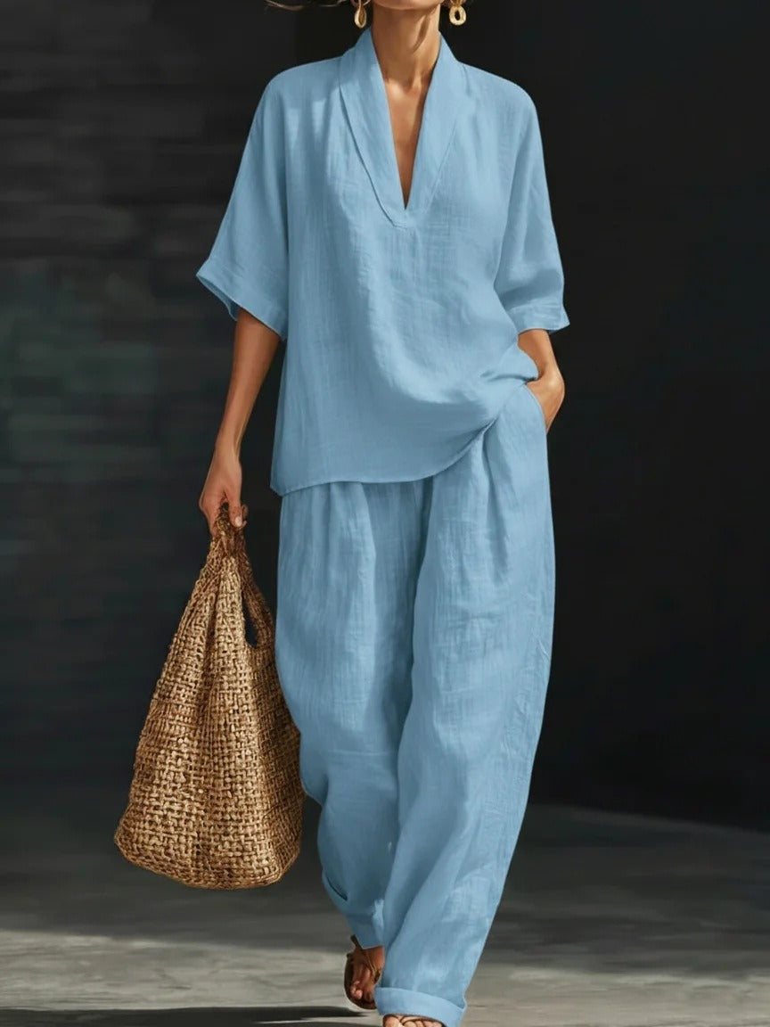 Conjunto casual de dos piezas para mujer en azul claro con blusa de cuello en V, pantalón ancho y bolso de paja.
