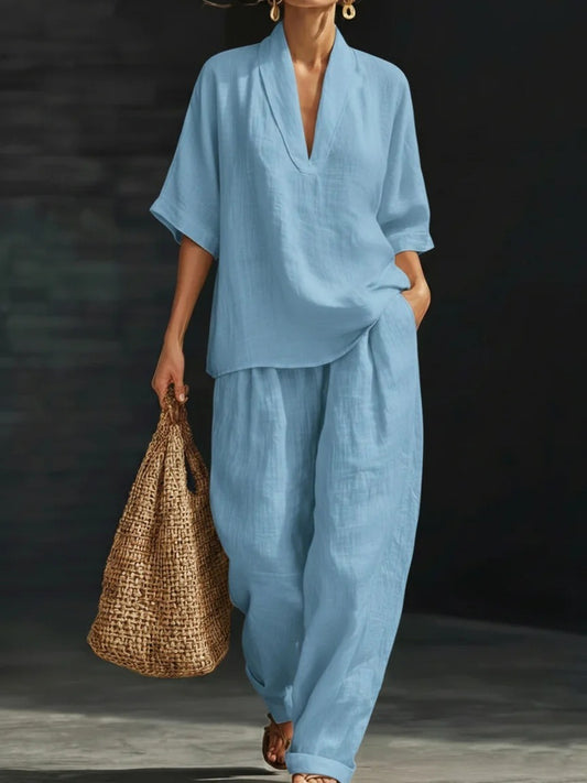 Conjunto casual de dos piezas para mujer en azul claro con blusa de cuello en V, pantalón ancho y bolso de paja.